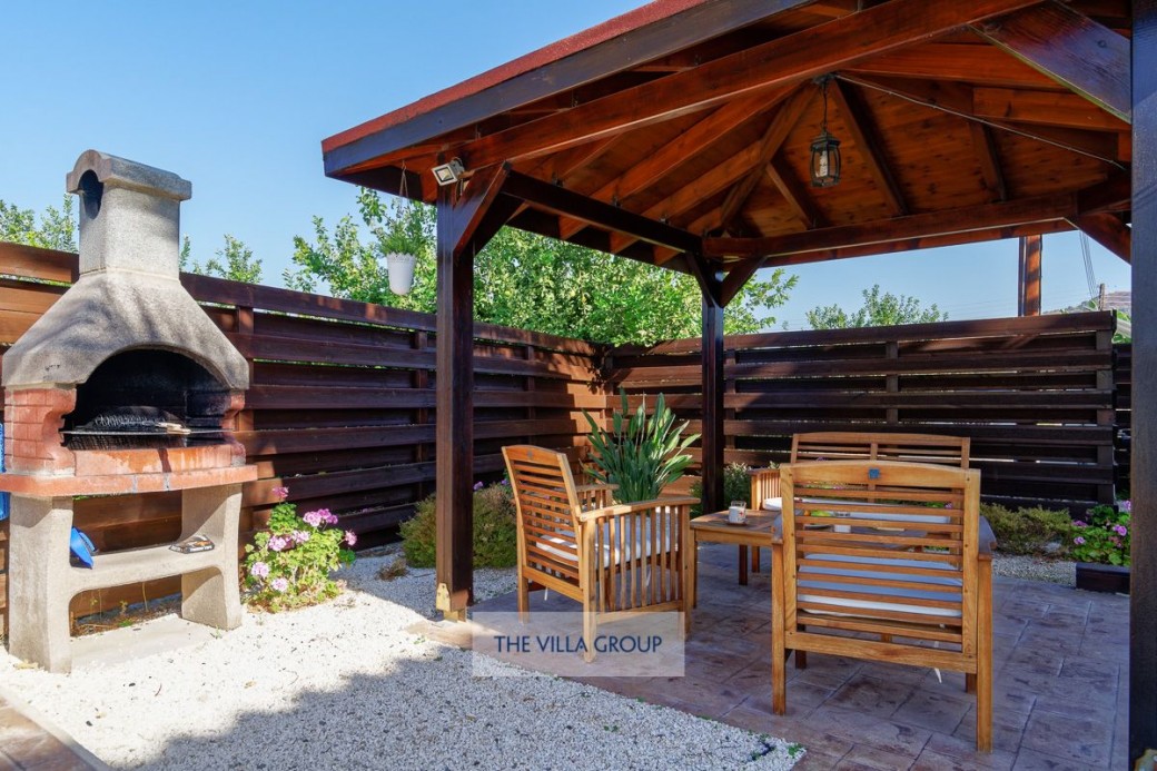 A shady pergola next to the pool with comfortable seating provides respite from the heat of the midday sun