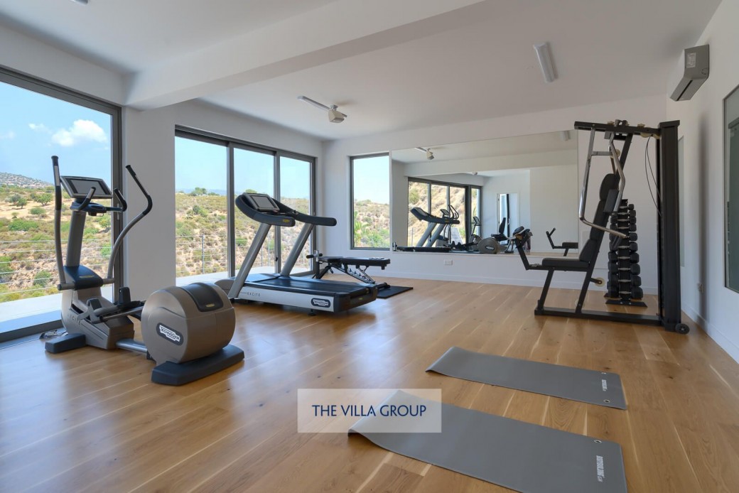 Stairs lead you down to the lower level, where a modern gym with fitness equipment is located for the more energetic members of the group