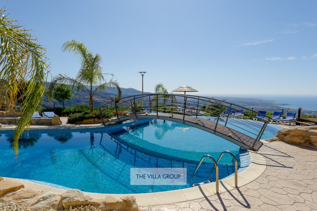 Bridge across the freeform infinity swimming pool
