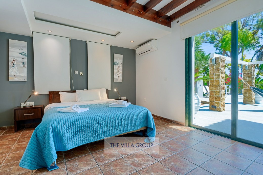 Master bedroom with patio doors leading to the outside terrace