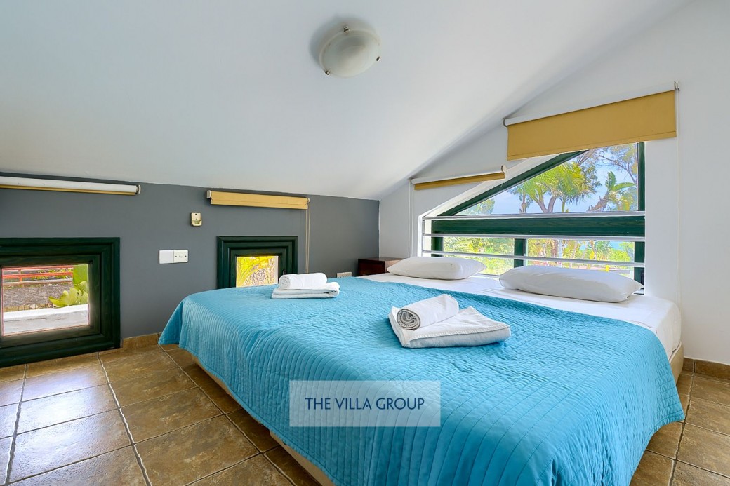Corner alcove with sloped ceiling has been furnished with two small single beds