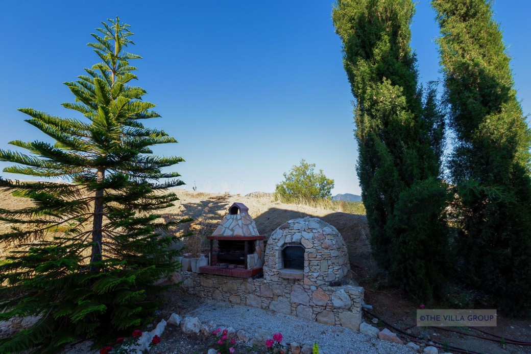 Large traditional style stone built barbecue and a traditional clay oven