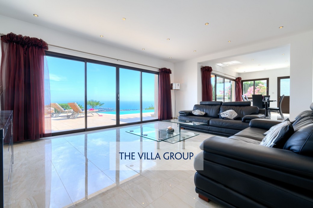Large sliding glass doors opening to furnished terrace and swimming pool 