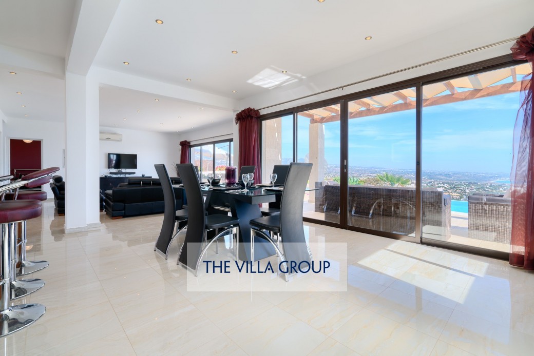 Large sliding glass doors opening to furnished terrace and swimming pool 