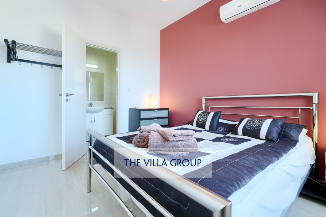 Ground floor double bedroom furnished with a chest of drawers and clothes rail
