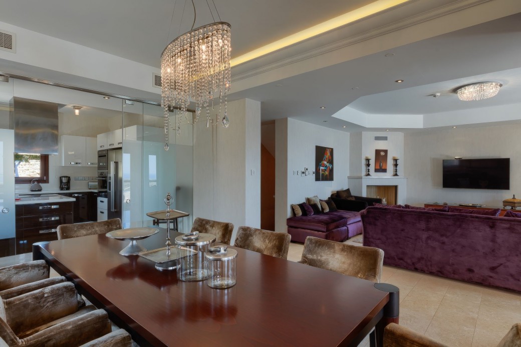 Beautifully furnished living area boasts plush armchairs and a sofa facing the graceful feature fireplace