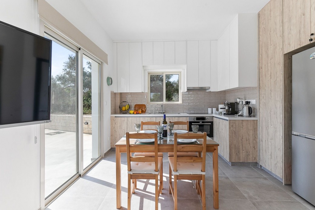 Patio doors from kitchen lead to the outside terrace and swimming pool