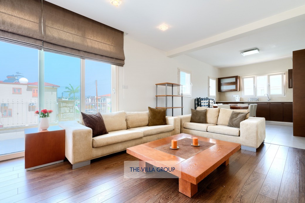 First floor living area with plenty of comfortable seating, TV and kitchen area