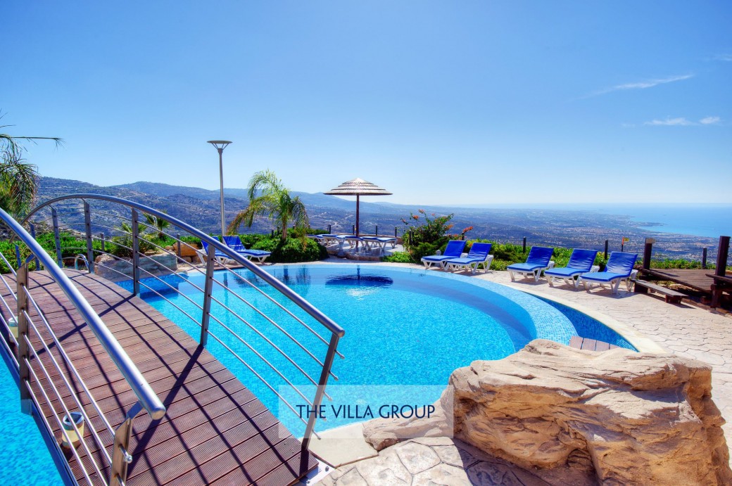 Bridge across the freeform infinity swimming pool
