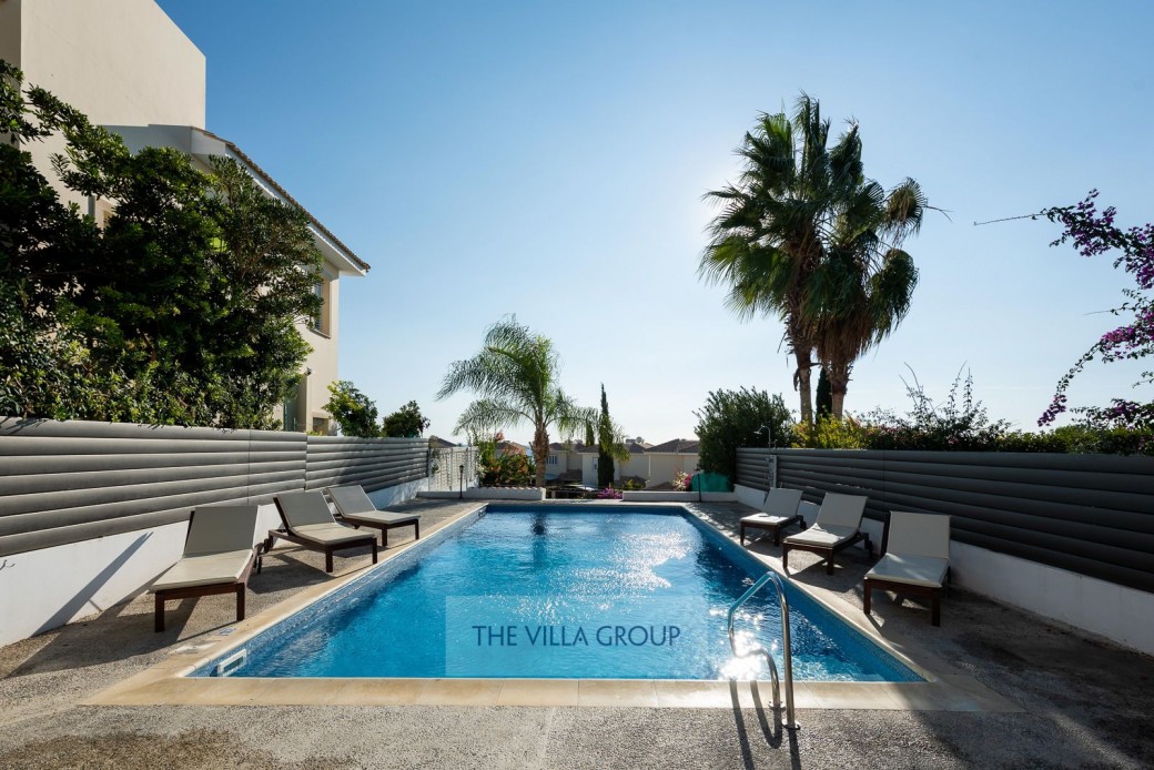 Private swimming pool surrounded by sunbeds for relaxing