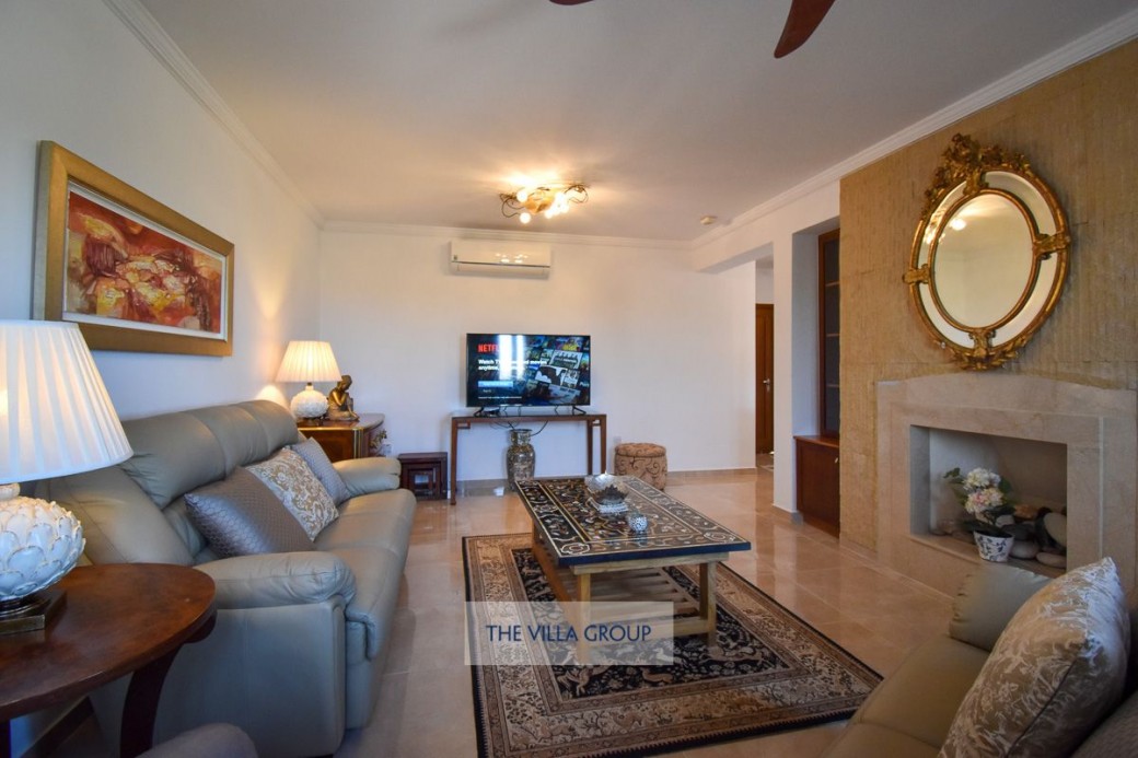 Living area with lovely decor, comfortable seating, a feature wall and decorative fireplace