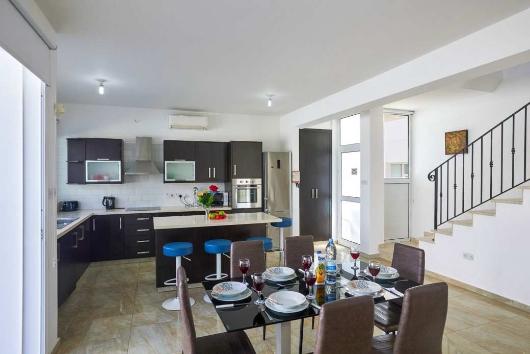 The modern kitchen is fitted with modern day appliances and features a granite breakfast bar