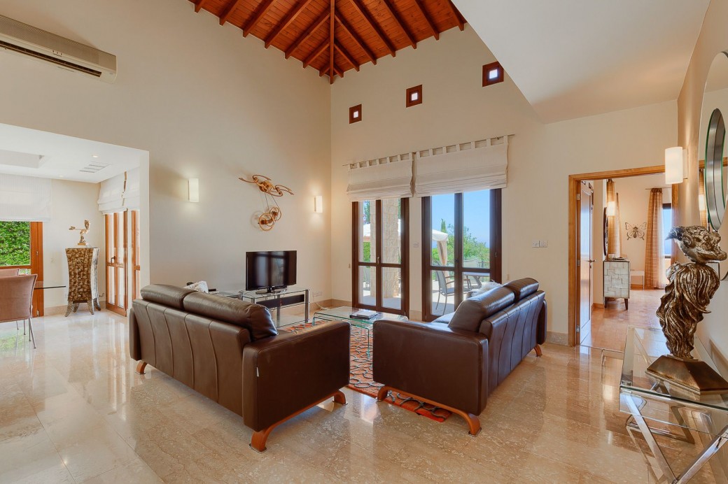 Living area with large windows opening out to the pool and patio area.