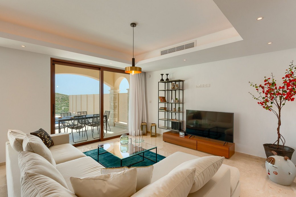 The lounge is beautifully finished with a cool white L-shaped sofa, TV and delightful accessories and wall art
