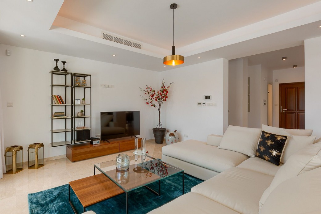 Second lounge area  featuring a 3-seater light beige sofa and two fashionable armchairs