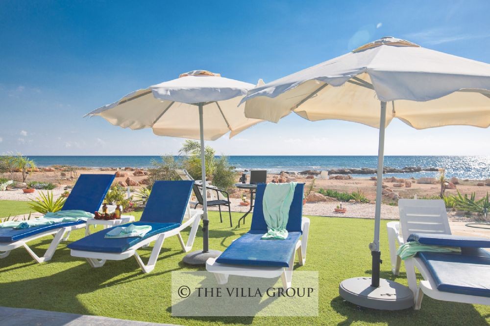 Sun loungers on grassy patch in front of villa