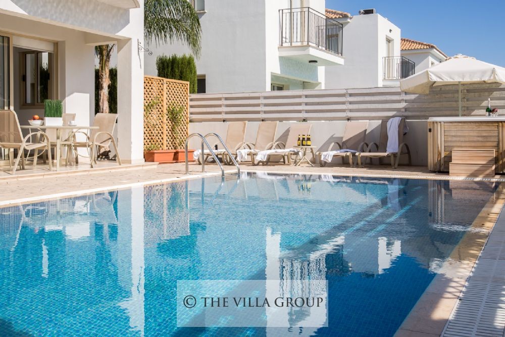 Swimming pool sided by sun loungers