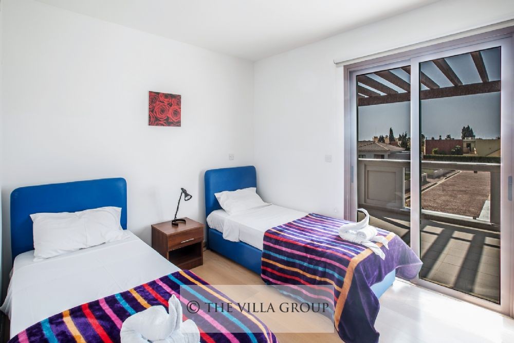 Second bedroom with twin beds and patio doors to balcony
