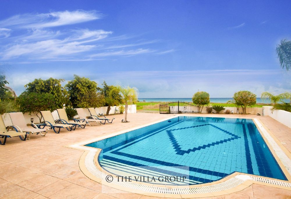 Swimming pool area sided by sun loungers with panoramic view of the sea