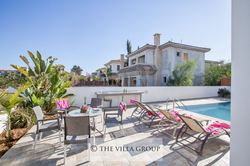 Sun loungers and patio table by the swimming pool