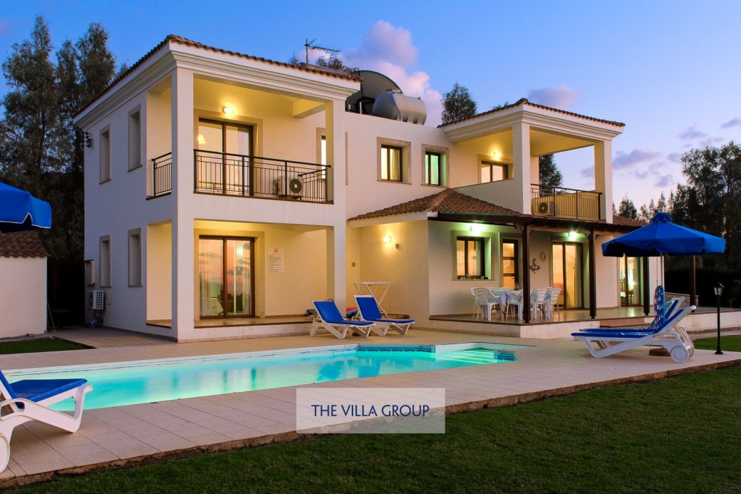 The villa lit at sunset
